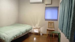 a bedroom with a bed and a flat screen tv at 民泊kururu 個室 鍵付き朝パン付きライダー用ガレージ有り in Nishidani