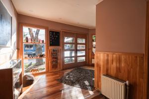 a living room with wooden floors and a large window at Hotel Aquaterra in Puerto Natales