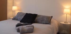 a bedroom with a bed with two pillows and two lamps at Gîte les falaises à barjac in Barjac