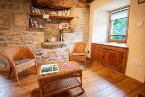 a living room with two chairs and a table at Le gite de granade in Barjac