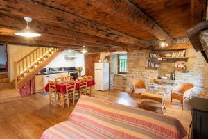 a kitchen and a living room with a table and chairs at Le gite de granade in Barjac