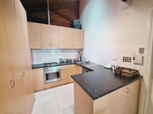 a kitchen with wooden cabinets and a black counter top at Intermission in Queenscliff