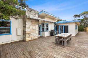 a picnic table on a deck in front of a house at Lochaber in Point Lonsdale