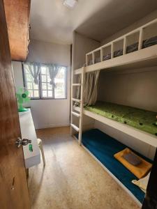 a room with two bunk beds and a window at Kochimoto Guesthouse in Baguio