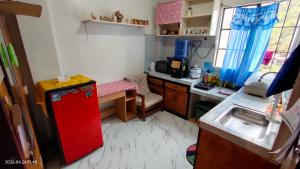 a small kitchen with a red refrigerator and a sink at Kochimoto Guesthouse in Baguio