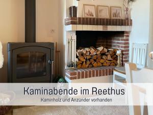 a fireplace in a living room with a pile of fire wood at Reetdachhaus in Seenähe, Ruhige Lage, Kamin & Terrasse in Seedorf +55 photos