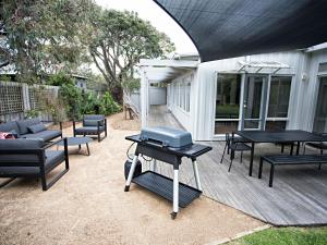 a patio with black tables and chairs and a grill at Lonsdale on Glaneuse in Point Lonsdale