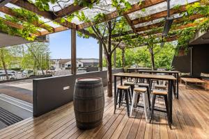 a bar with wooden tables and stools and a barrel at Townhouse Hotel in Wagga Wagga