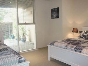 a bedroom with a bed and a large window at Lonsdale Shores in Point Lonsdale