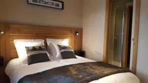 ein Schlafzimmer mit einem großen weißen Bett mit schwarzen Kissen in der Unterkunft Appartements Bétemps in Le Grand-Bornand