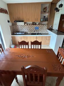 a kitchen with a wooden table with chairs and a sink at Yalyn's Hometel Kabankalan in Kabankalan +6 photos
