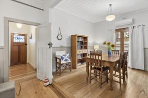 a kitchen and dining room with a table and chairs at Maison Cottage in Queenscliff