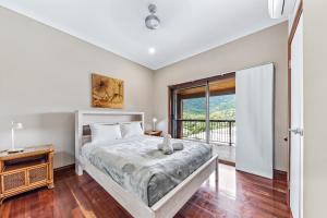 a bedroom with a bed and a balcony at Seascape Paradise in Airlie Beach