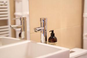 a bathroom sink with a mirror and a bottle of soap at Hotel Aquaterra in Puerto Natales +54 photos