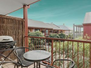 a patio with a table and chairs on a balcony at Marley s Place in Queenscliff