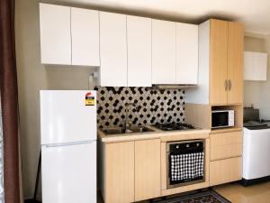 a kitchen with white cabinets and a white refrigerator at Trendy Edge Apartments in Nadi