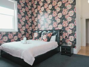 ein Schlafzimmer mit einem Bett mit floraler Tapete in der Unterkunft Ozone Tower in Queenscliff