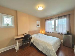 a bedroom with a bed and a desk and window at TORONTO Midtown HomeHaven in Toronto