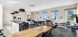 a kitchen and living room with a table and chairs at Penthouse Ozone in Queenscliff +7 photos