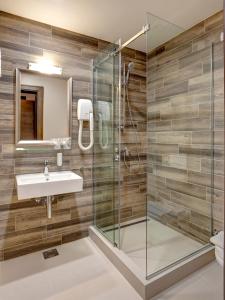 La salle de bains est pourvue d'une douche en verre et d'un lavabo. dans l'établissement Garni Hotel Zavicaj, à Belgrade