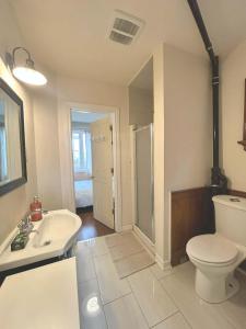 a white bathroom with a toilet and a sink at TORONTO Midtown HomeHaven in Toronto