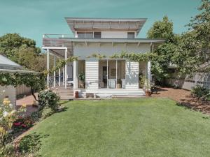 a white house with a lawn in front of it at Ripview in Point Lonsdale