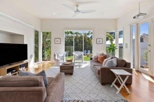 a living room with a couch and a flat screen tv at Ripview in Point Lonsdale