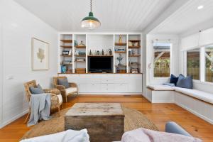 a living room with a couch and a tv at Ripview in Point Lonsdale +7 photos