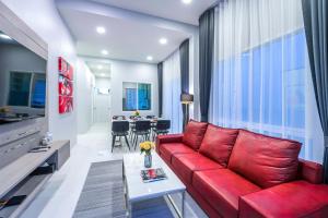 a living room with a red couch and a table at The Garnet Light Pool Villa Aonang-3BR Private Pool Villa in Ao Nang Beach