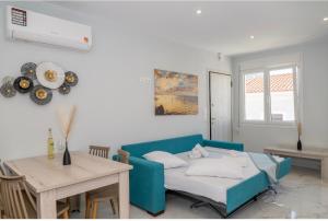 a living room with a blue couch and a table at Rhea Central Luxury Apartment in Samos