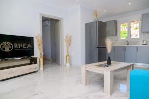 a living room with a tv and a table at Rhea Central Luxury Apartment in Samos