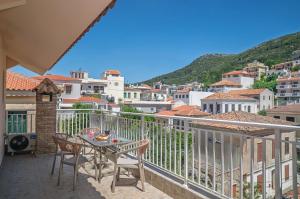 a patio with a table and chairs on a balcony at Rhea Central Luxury Apartment in Samos