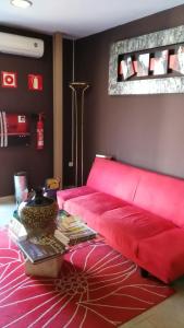 a red couch in a living room with a table at Costa HP in Castelldefels