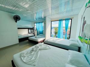 a bedroom with two beds and a large window at Apartahotel Dazuwi in Doradal