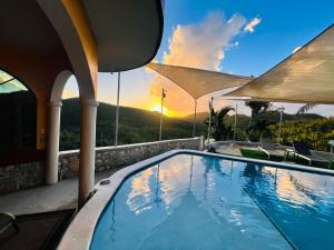 a swimming pool with a sunset in the background at The Crown Private Queen in Mount Terza