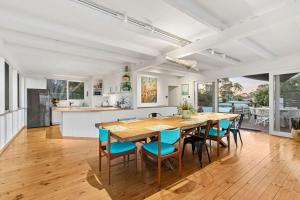 a kitchen and dining room with a large wooden table and chairs at The Springs in Point Lonsdale