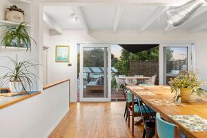 a dining room with a long table and chairs at The Springs in Point Lonsdale +5 photos