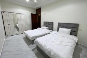 a bedroom with two beds and a mirror at هلا شاليه اتين in Salalah