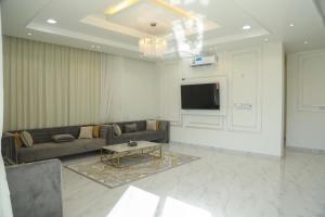 a living room with a couch and a tv at هلا شاليه اتين in Salalah