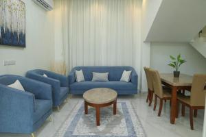 a living room with blue couches and a table at هلا شاليه اتين in Salalah +4 photos