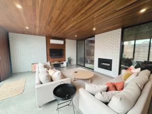 a living room with two white couches and a fireplace at Stella on Stevens in Queenscliff