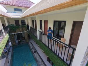 a man standing on the balcony of a house with a swimming pool at Umah Bagus in Sanur
