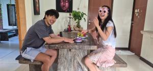 a man and a woman sitting on a bench at Umah Bagus in Sanur