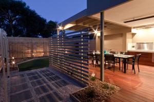a backyard with a dining table and a fence at Taworri in Queenscliff