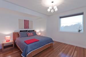 a bedroom with a large bed with a window at Taworri in Queenscliff