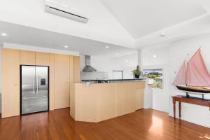 a kitchen with white walls and a wooden counter top at The Beach House in Point Lonsdale