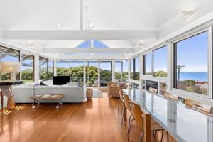 a living room with a white couch and windows at The Beach House in Point Lonsdale