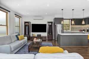 a living room with a couch and a kitchen at The Scoop in Queenscliff