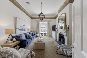 a living room with a blue couch and a fireplace at QPO Queenscliff in Queenscliff