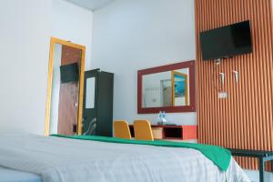 a bedroom with a bed and a mirror and a desk at Noah Hotel Silangit in Siborongborong